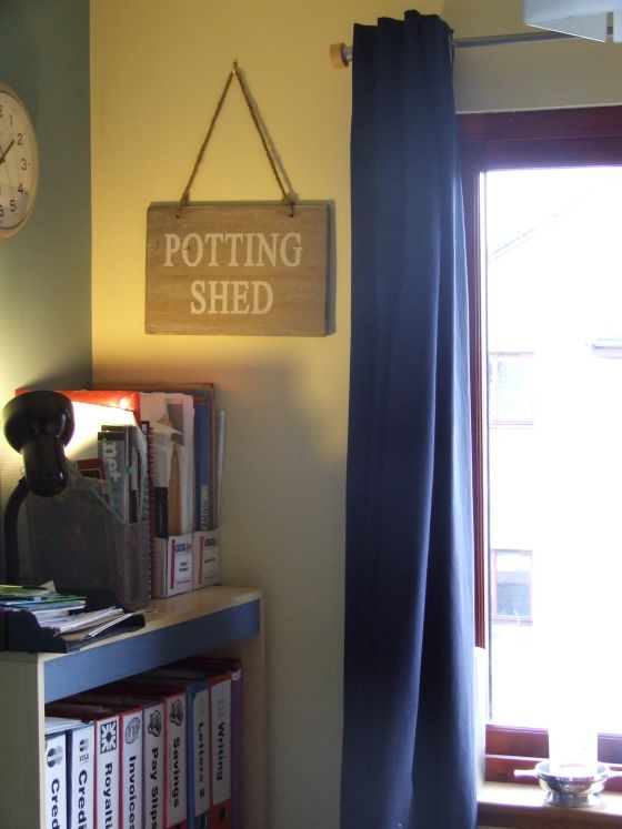 Sign hanging on the wall that says "Potting Shed".